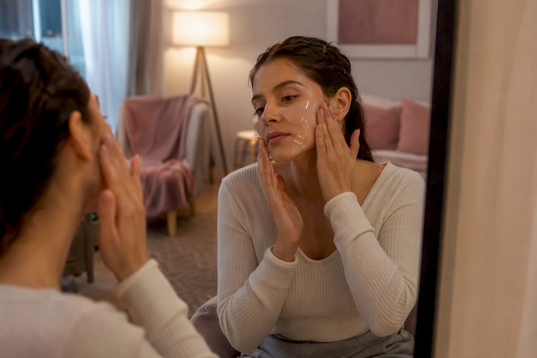 Hands applying hydrogel face mask at night