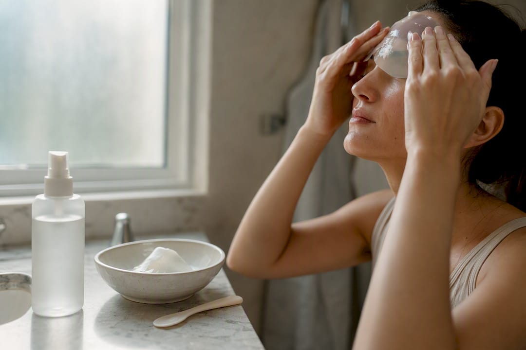 Hand applying hydrogel mask on face